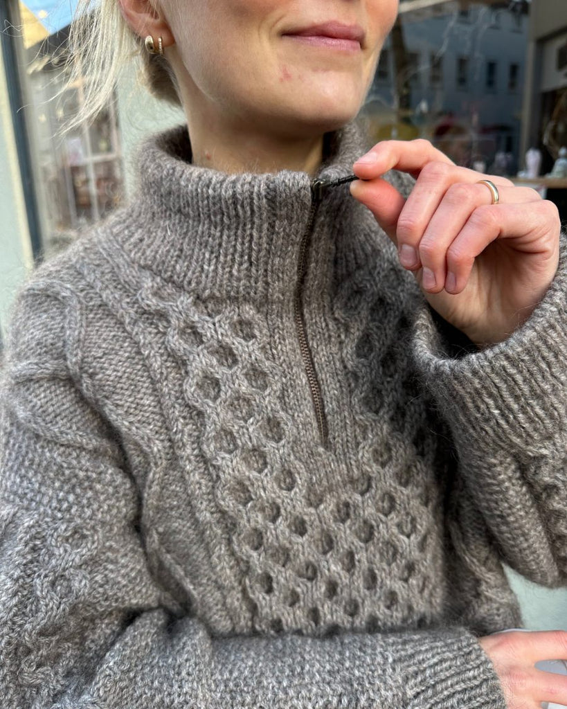 Detaljebillede af kvinde iført grå Dagmar Zipper Sweater 