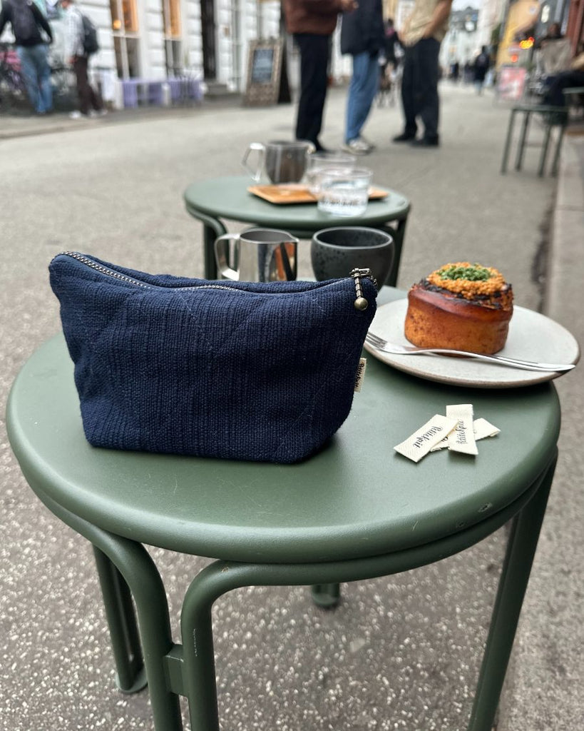 Knitter's tool kit i mørkeblå stående på cafebord